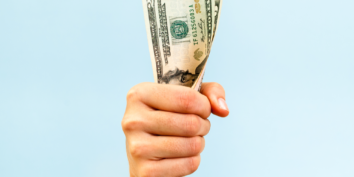 Hand holding money bootstrapping business